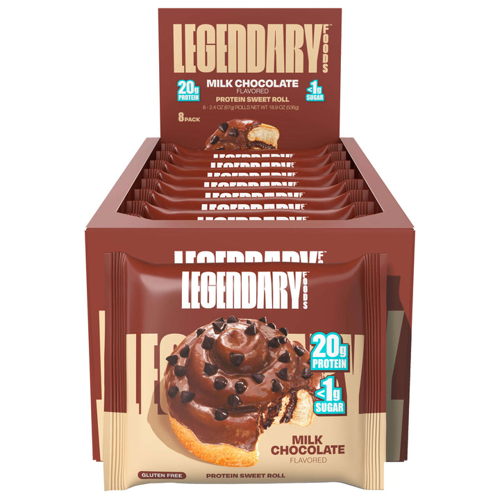 An open retail display box of Legendary Foods Milk Chocolate Protein Sweet Rolls. Multiple individual packages are neatly arranged in the box, each showing the same visual branding—chocolate frosted roll with chocolate chips and a bite missing, alongside “20g Protein” and “<1g Sugar” labels.