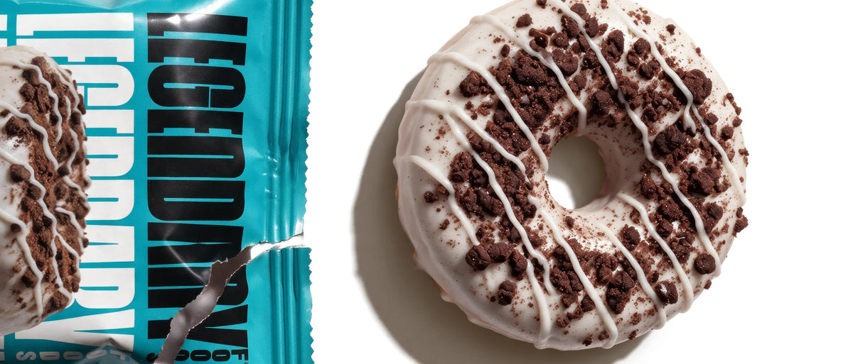 Image of open Legendary Foods Cookies & Cream Protein Donut packaging with one donut on a white background.