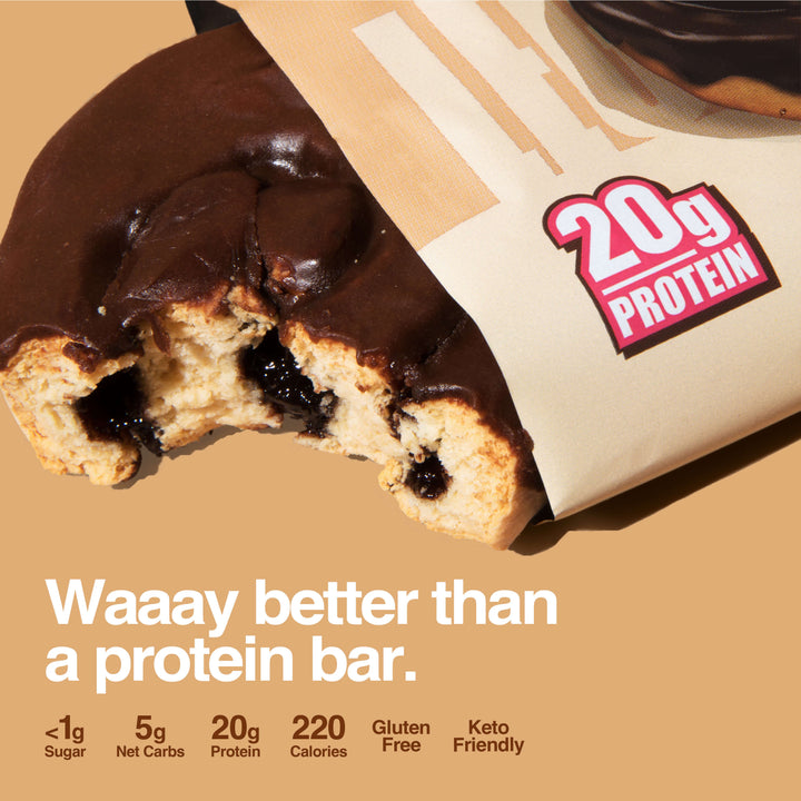 Chocolate protein sweet roll with a bite, showing filling, next to a wrapper marked 20g protein.