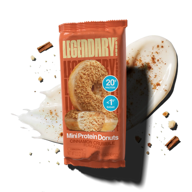 Package of cinnamon crumble mini protein donuts with cinnamon icing and cinnamon sticks in the background