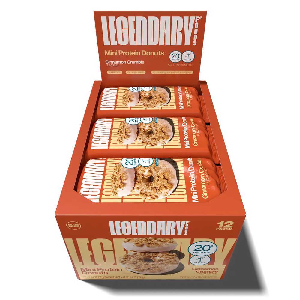 Open 12-pack display box of Legendary Foods Cinnamon Crumble Mini Protein Donuts, showing individually wrapped packages in orange packaging.