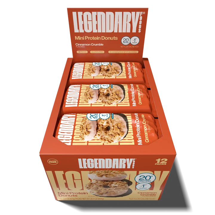 Open 12-pack display box of Legendary Foods Cinnamon Crumble Mini Protein Donuts, showing individually wrapped packages in orange packaging.