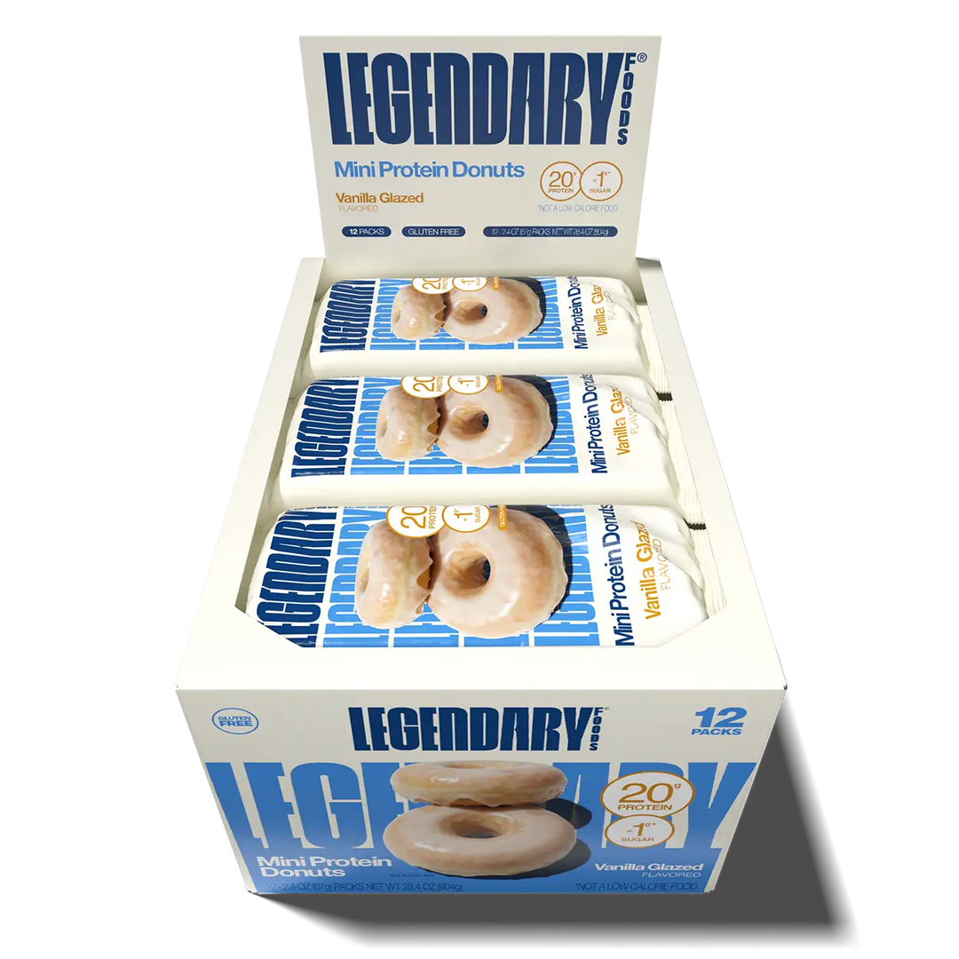 Open 12-pack box of Legendary Foods Vanilla Glazed Mini Protein Donuts displaying individually wrapped packages, each containing two donuts.