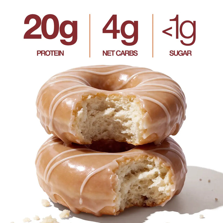 Two Maple Glazed Mini Protein Donuts with glossy maple glaze and white drizzle, shown with 20g protein, 4g net carbs and less than 1g sugar callouts.