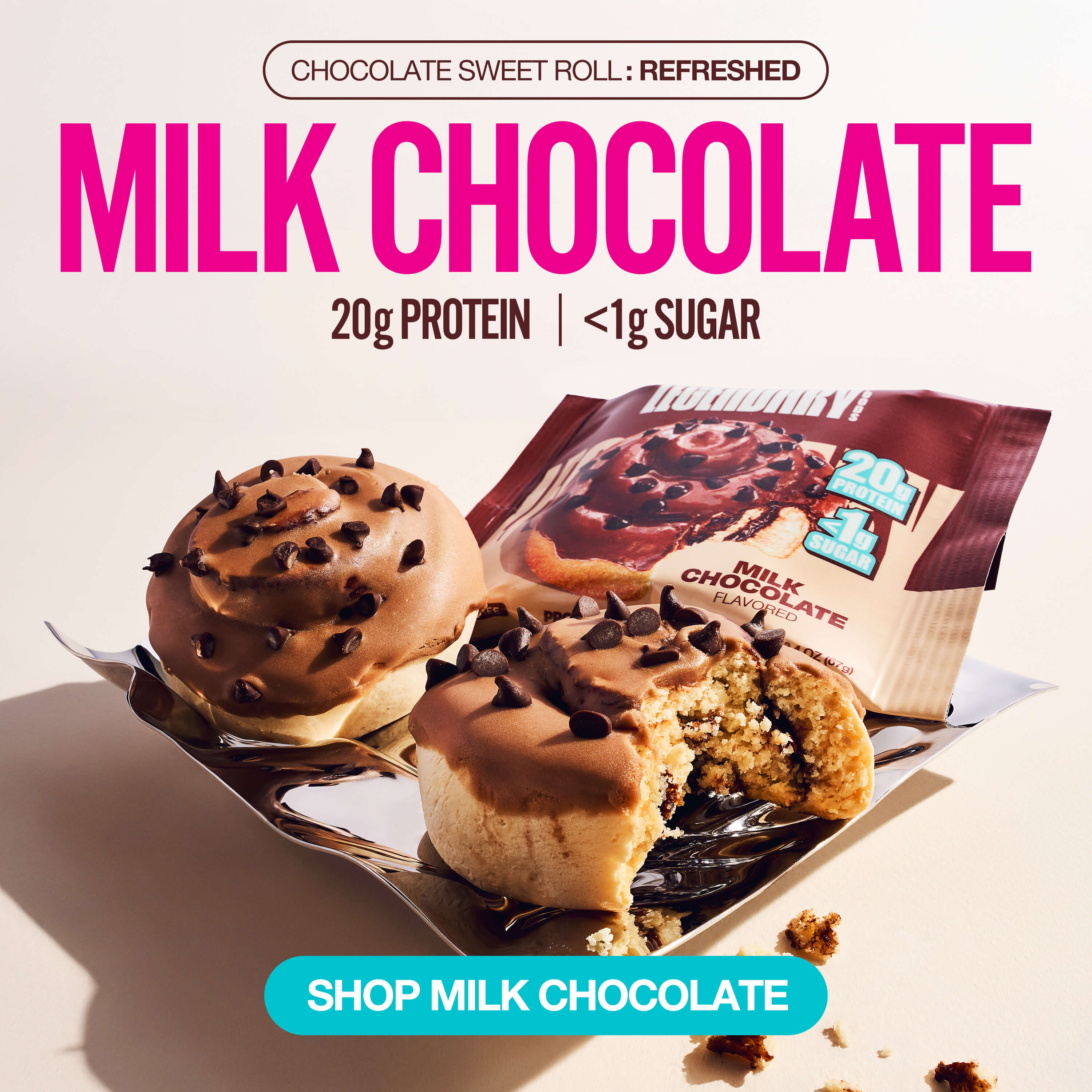 Chocolate chip–topped protein sweet rolls with packaging. Bold text reads “Milk Chocolate” and promotes 20g protein, <1g sugar.