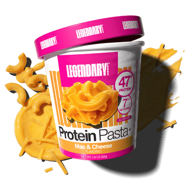 Angled cup of Protein Pasta Mac & Cheese with cheddar cheese and noodles in the background